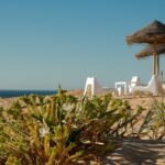 Spiaggia dell'Algarve con sabbia bianca e mare turchese, scenario paradisiaco simile ai Caraibi.