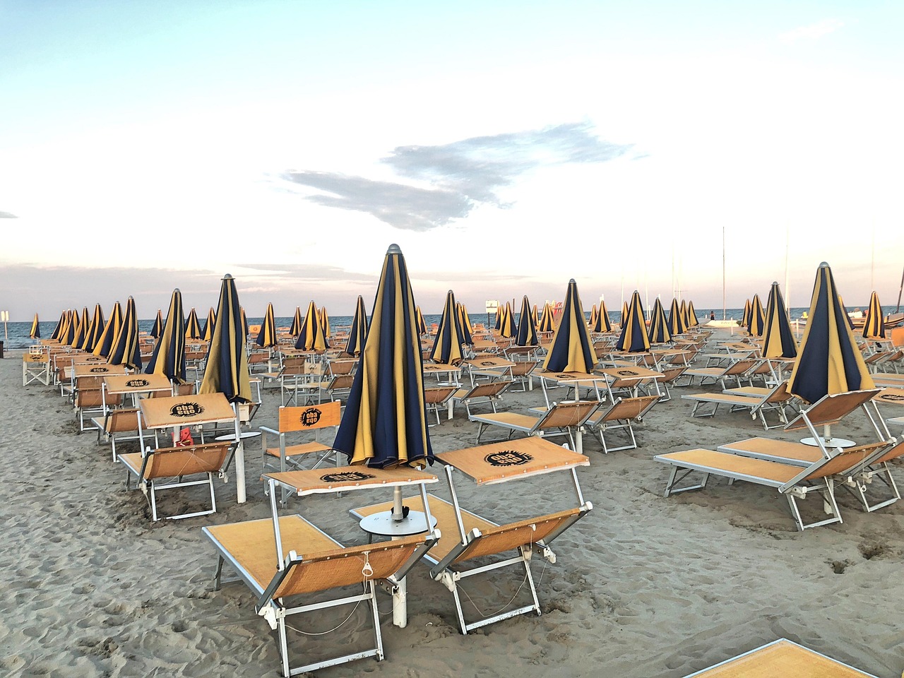 Spiaggia di Rimini affollata con ombrelloni, evidenziando gli errori comuni dei turisti al mare.