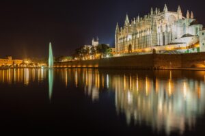 Spiaggia tranquilla a Palma di Mallorca, frequentata dai locali, circondata da acque cristalline e sabbia dorata.