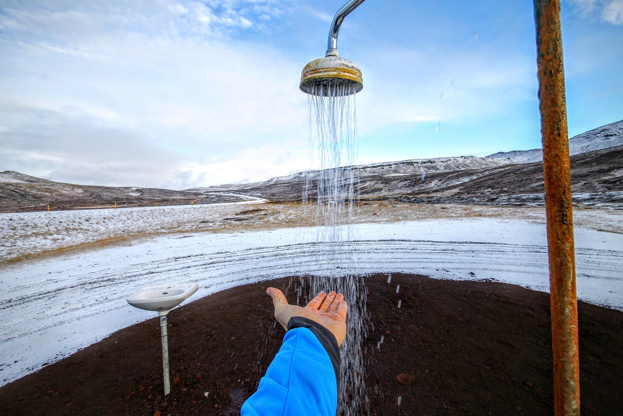 Uomo che si rilassa in una pozza termale con neve circostante durante l'inverno.
