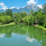 Lago del Trentino con acque cristalline e montagne sullo sfondo, paesaggio da cartolina.