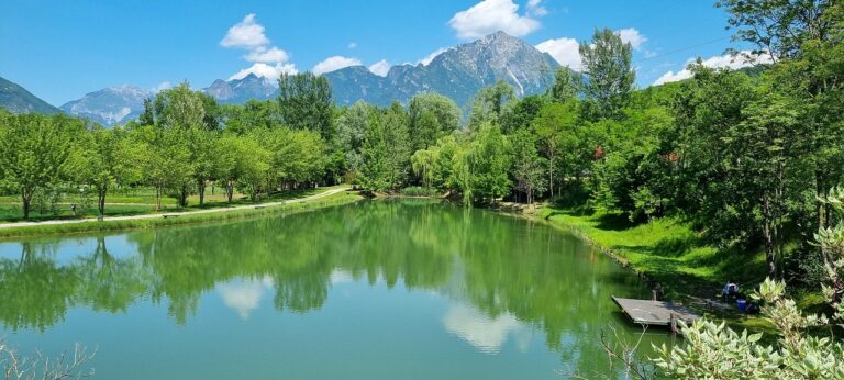 Lago del Trentino con acque cristalline e montagne sullo sfondo, paesaggio da cartolina.