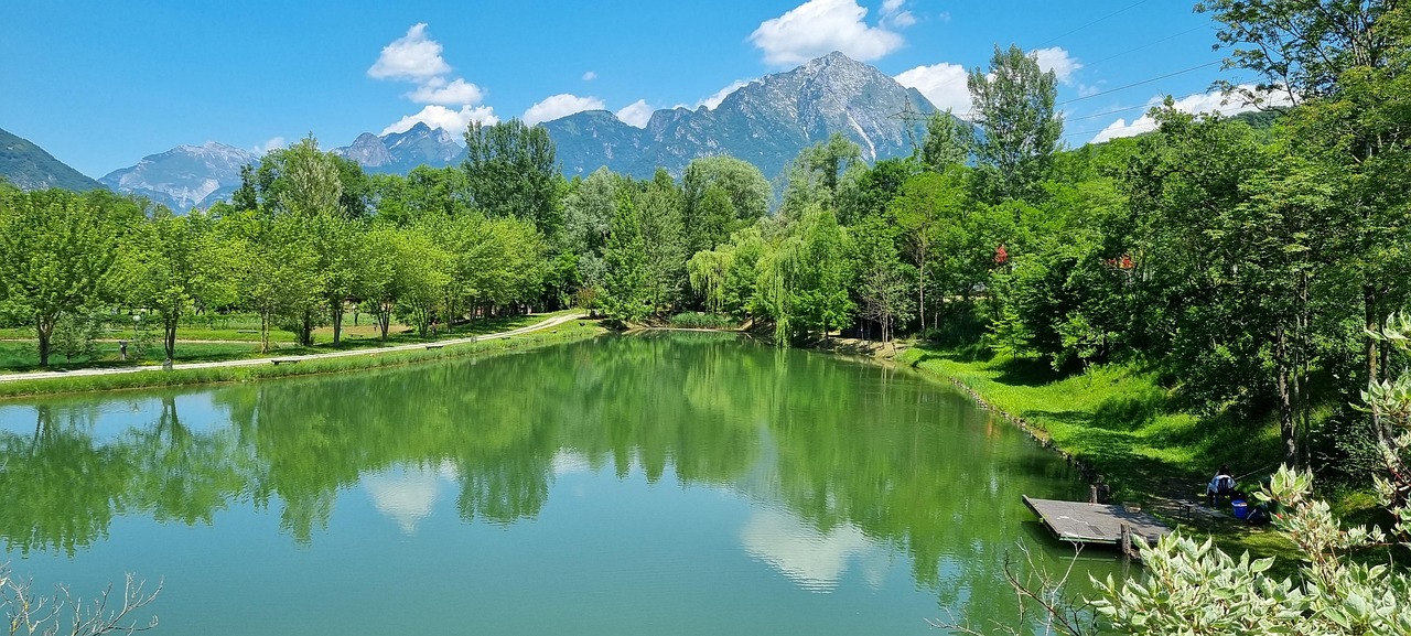 Lago del Trentino con acque cristalline e montagne sullo sfondo, paesaggio da cartolina.
