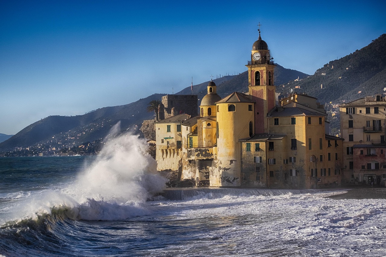 Panorama del suggestivo paese ligure affacciato sul mare, con case colorate e spiaggia dorata.