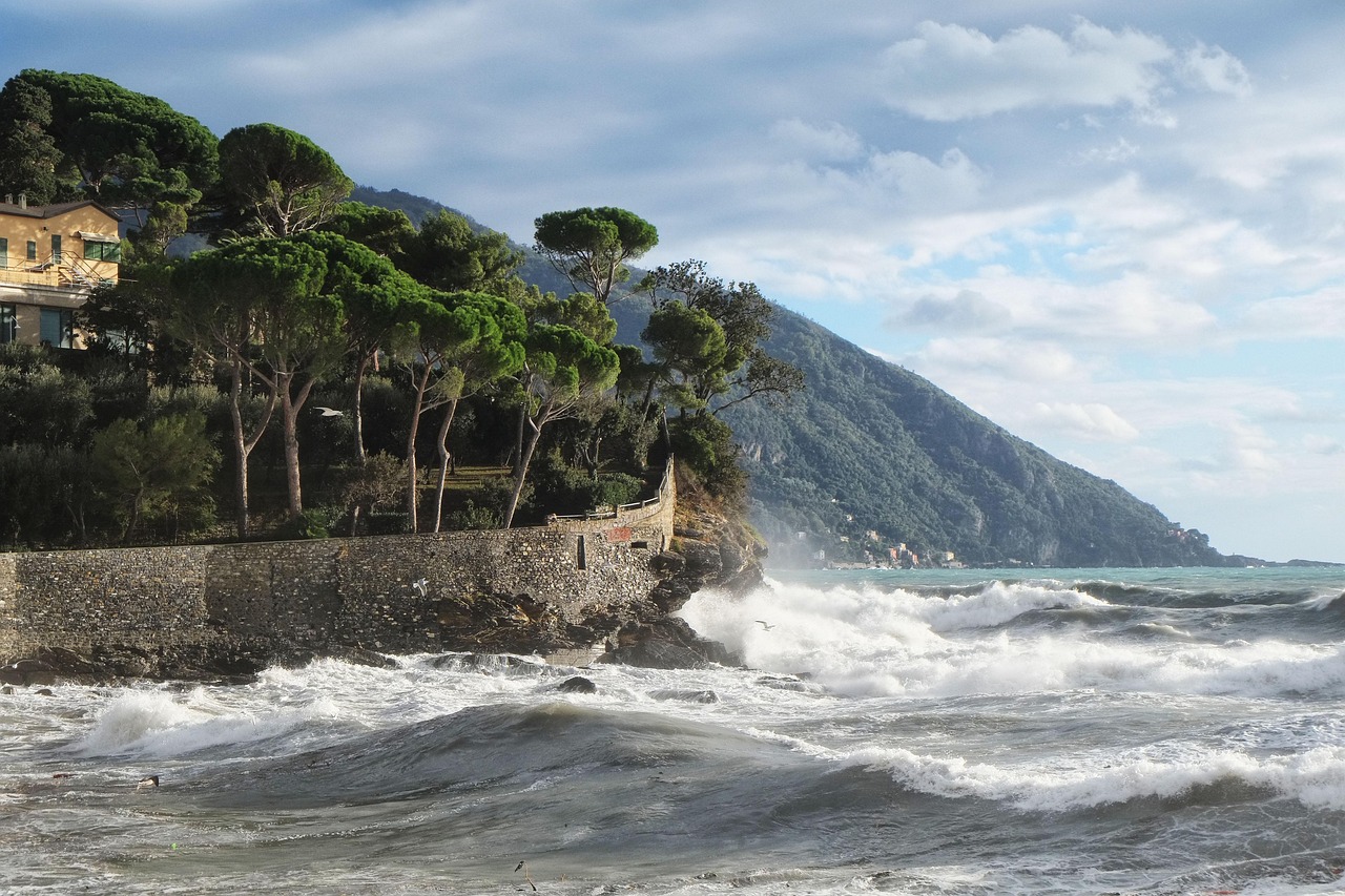 Spiaggia affollata in una località economica della Liguria, con ombrelloni e bagnanti sotto il sole.