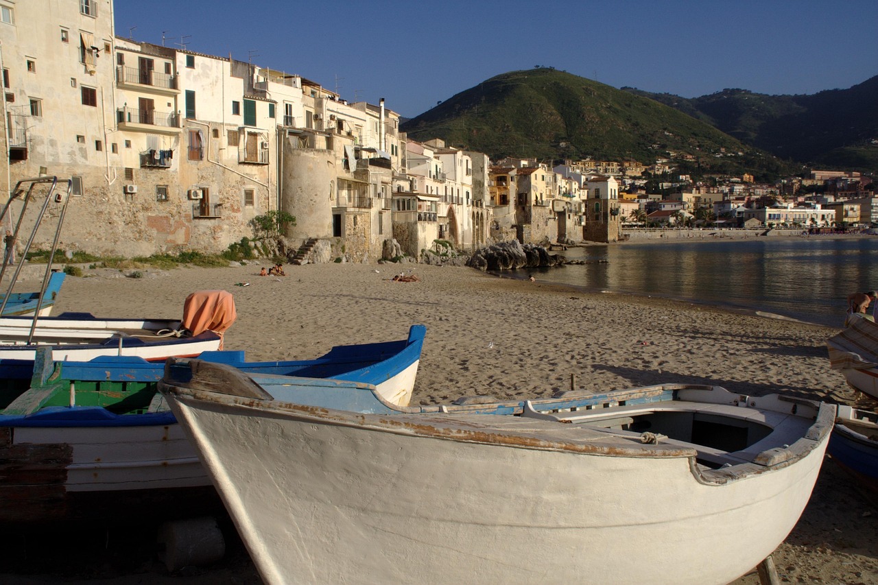Vista panoramica del borgo sul mare, con case colorate e spiaggia tranquilla al tramonto.
