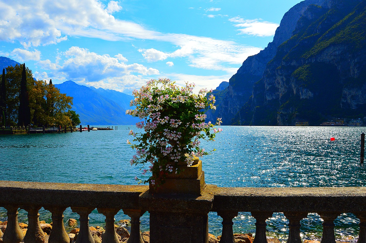 Panorama di un lago italiano circondato da fiori e vegetazione primaverile.