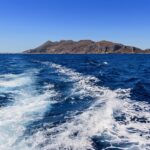 Paesaggio delle Eolie con mare cristallino e isole in lontananza, simbolo di un viaggio imperdibile.