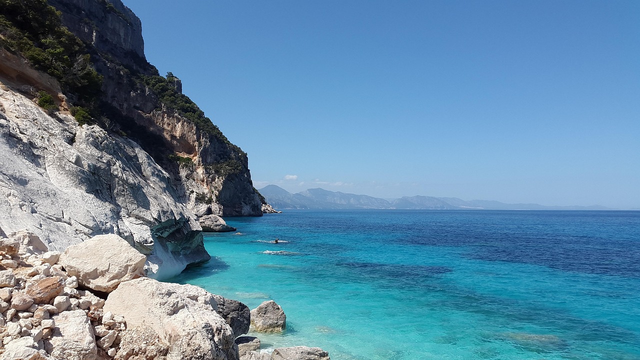 Spiaggia segreta in Sardegna con acque cristalline e sabbia bianca, immersa nella natura.