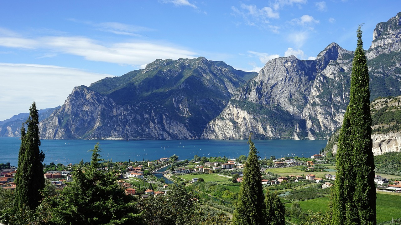 Vista panoramica del borgo di Riva del Garda con montagne sullo sfondo, perfetta per un'estate in montagna.
