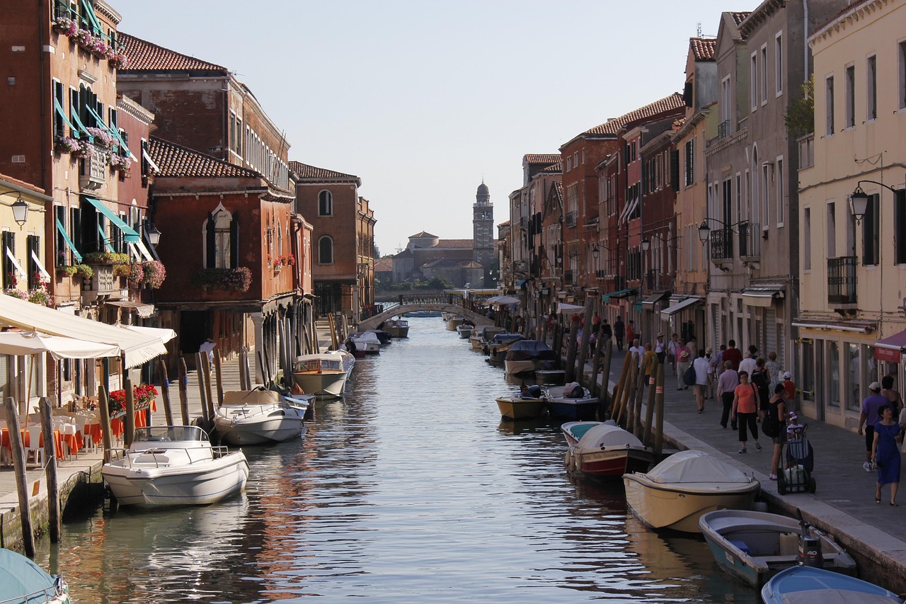 Immagine di Venezia con cartelli che avvertono sui prezzi elevati per dormire in alcune zone.