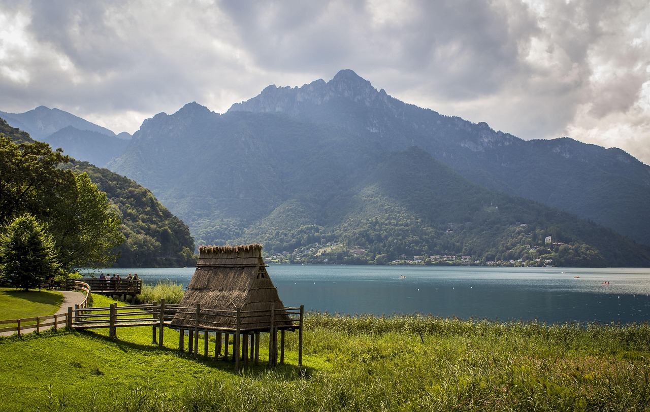 Vista panoramica del lago, circondato da montagne e vegetazione, simile a un fiordo norvegese.