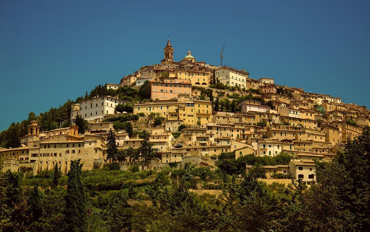 Panorama suggestivo di un paese marchigiano, con colline verdi e edifici storici.
