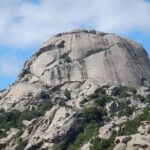 Panorama della Sardegna con cartello di avviso su prenotazioni obbligatorie per visitare la zona.