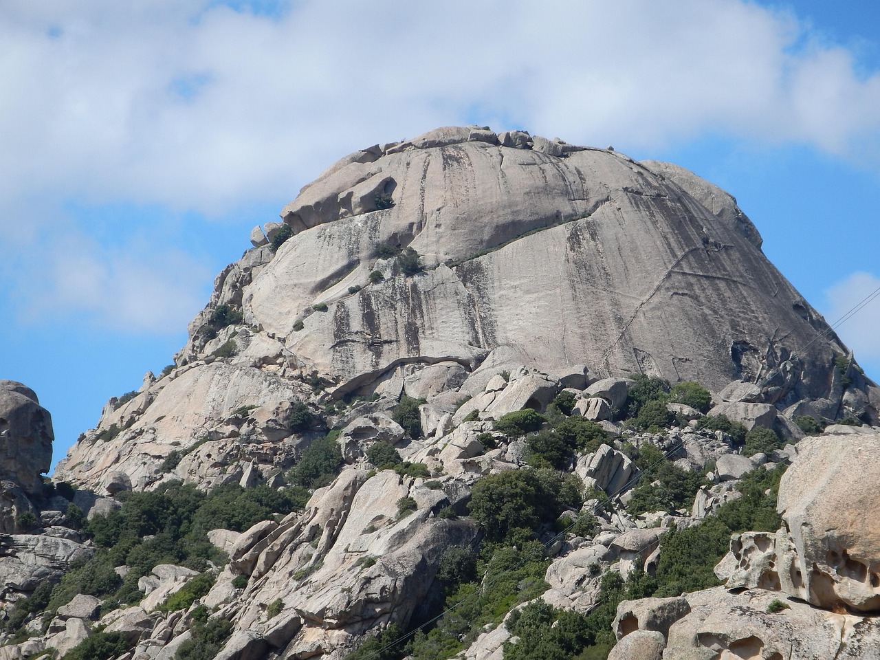 Panorama della Sardegna con cartello di avviso su prenotazioni obbligatorie per visitare la zona.