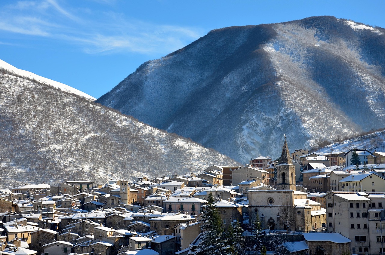 Panorama di un suggestivo borgo di montagna innevato, con case in legno e alberi coperti di neve.
