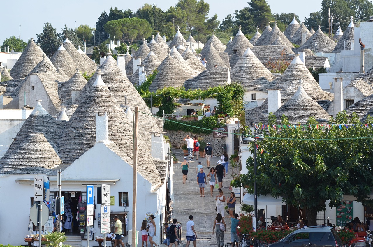 Piatti tipici di Alberobello serviti in un ristorante, con trulli sullo sfondo.