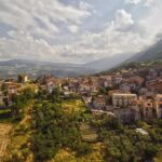 Panorama di un pittoresco paese campano con case colorate e paesaggi verdi.