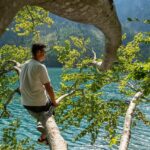 Lago di Molveno circondato da montagne, ideale per famiglie in estate con attività all'aperto e relax.