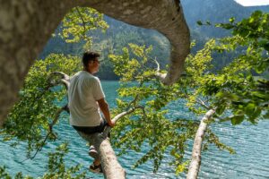 Lago di Molveno circondato da montagne, ideale per famiglie in estate con attività all'aperto e relax.