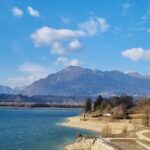 Lago incantevole in Friuli, circondato da montagne e vegetazione lussureggiante.