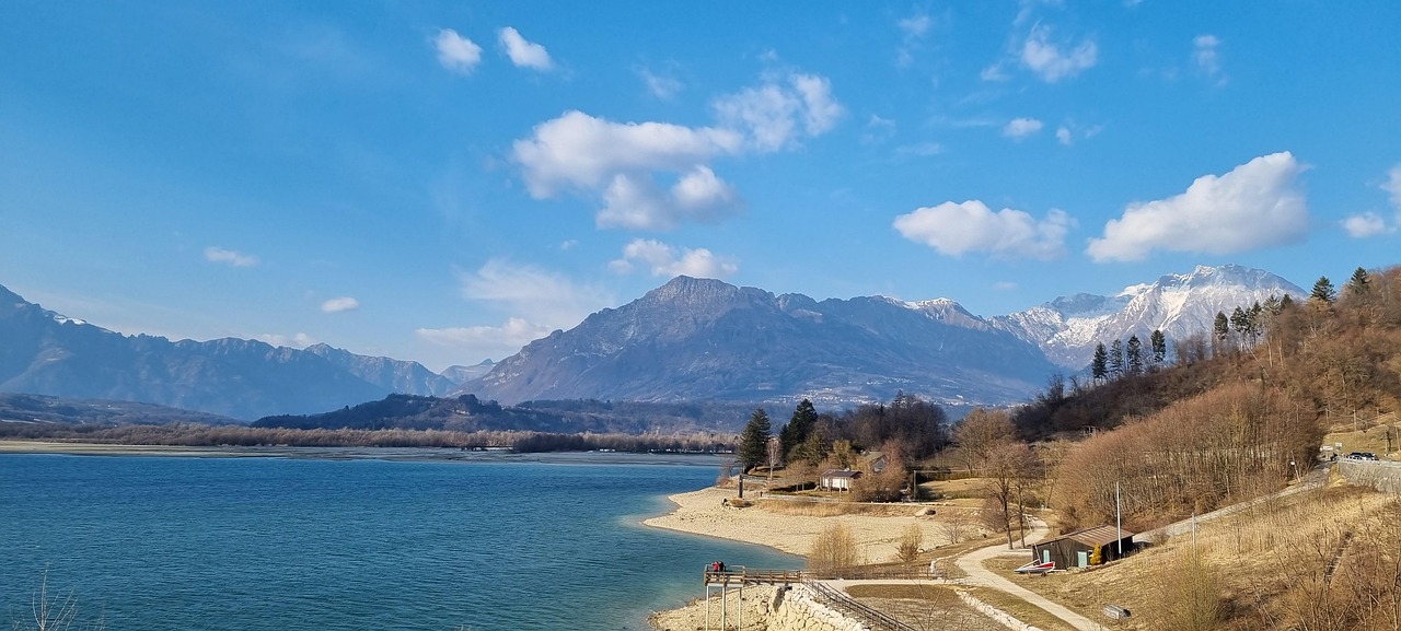 Lago incantevole in Friuli, circondato da montagne e vegetazione lussureggiante.