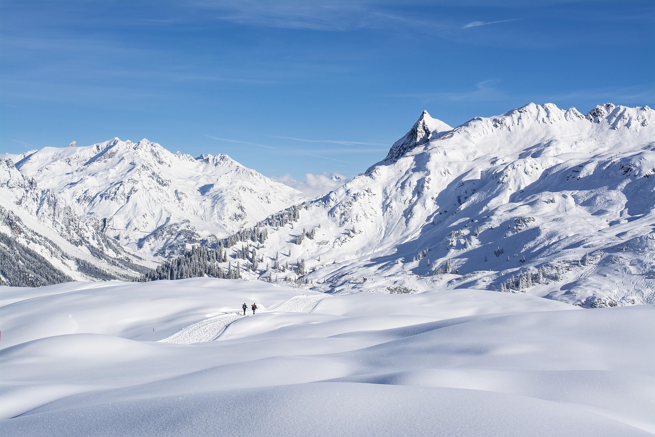 Panorama innevato di una località sciistica con piste affollate e paesaggio montano suggestivo.