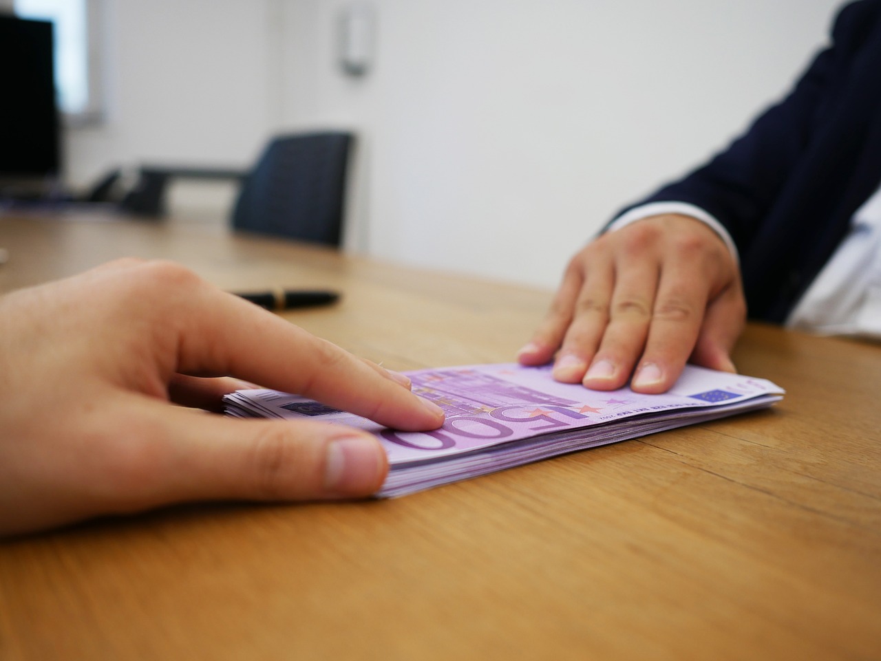 Giocatori di "Affari Tuoi" con banconote e premi in un momento di gioco emozionante.