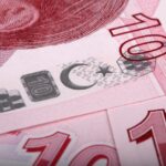 Immagine di un lucchetto su una banconota, simbolo di conto corrente bloccato e nuovi controlli finanziari.